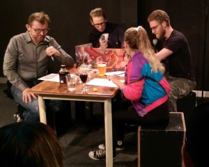 Fire komikere på en scene spiller rollespil